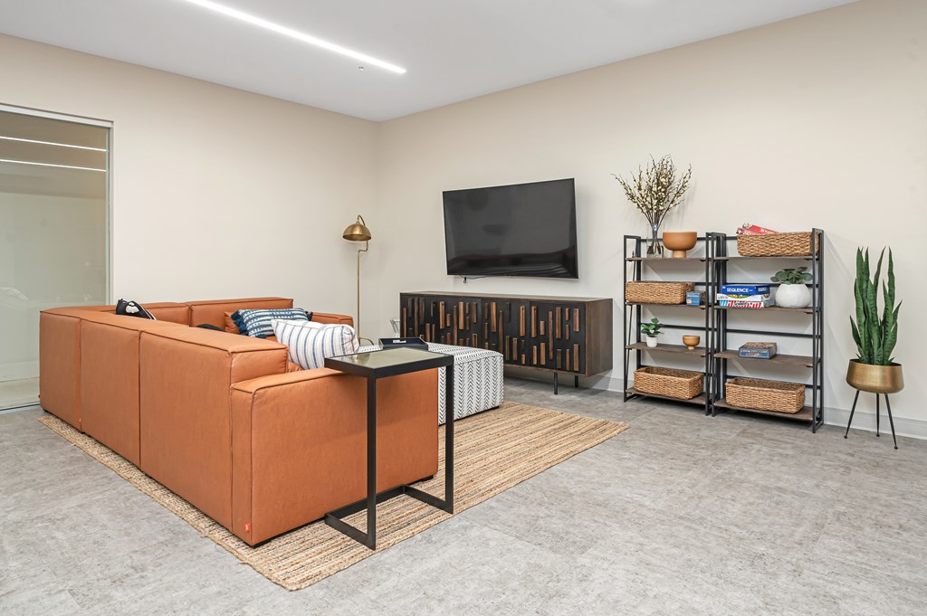 A living room with a sofa, a table, and a television.